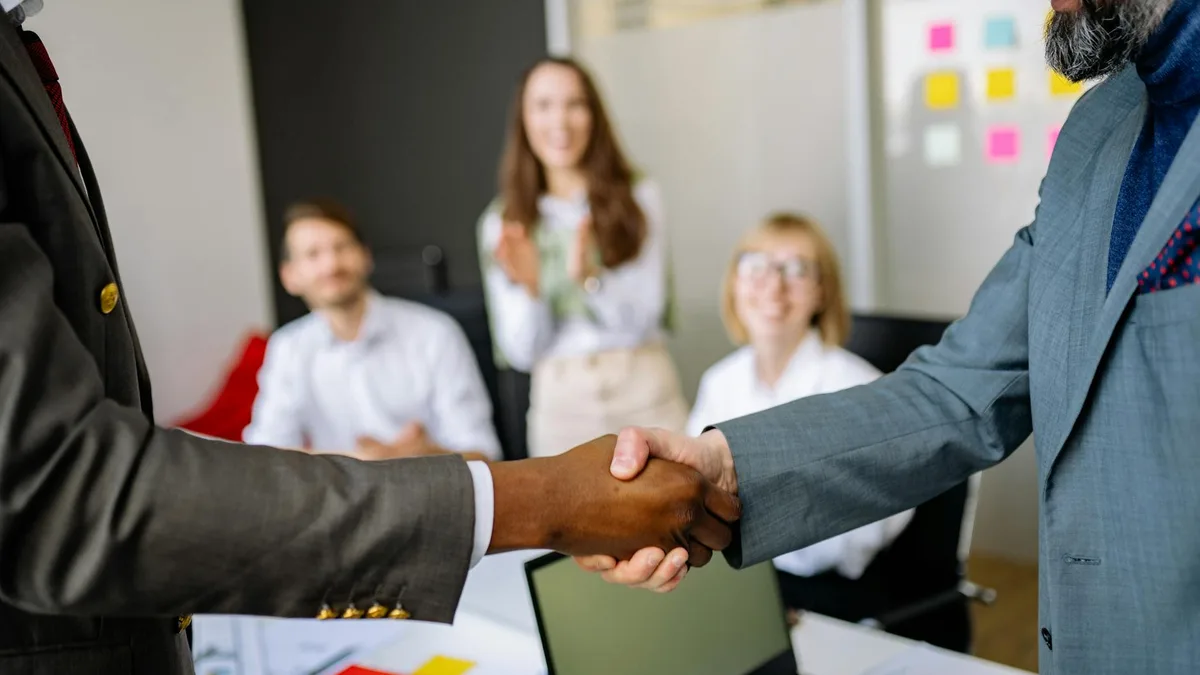 Two people shaking hands at a business meeting, choosing an AI automation agency partner