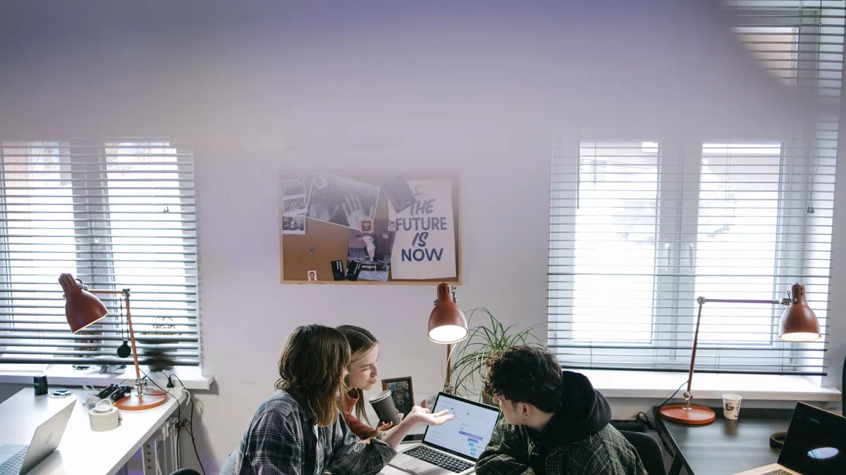 A team working on laptops in a modern office, the kind of operations an AI automation agency streamlines