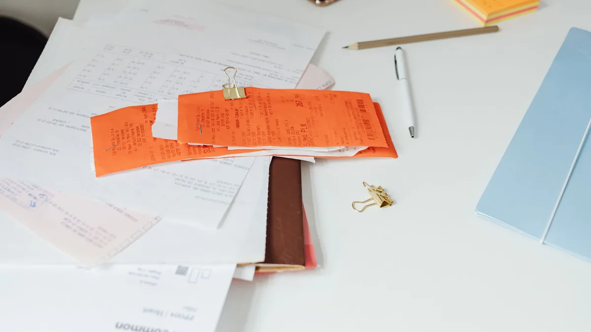 Stack of paper documents being processed at a desk