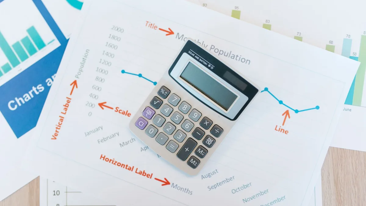 Calculator and financial documents on a desk for payback math