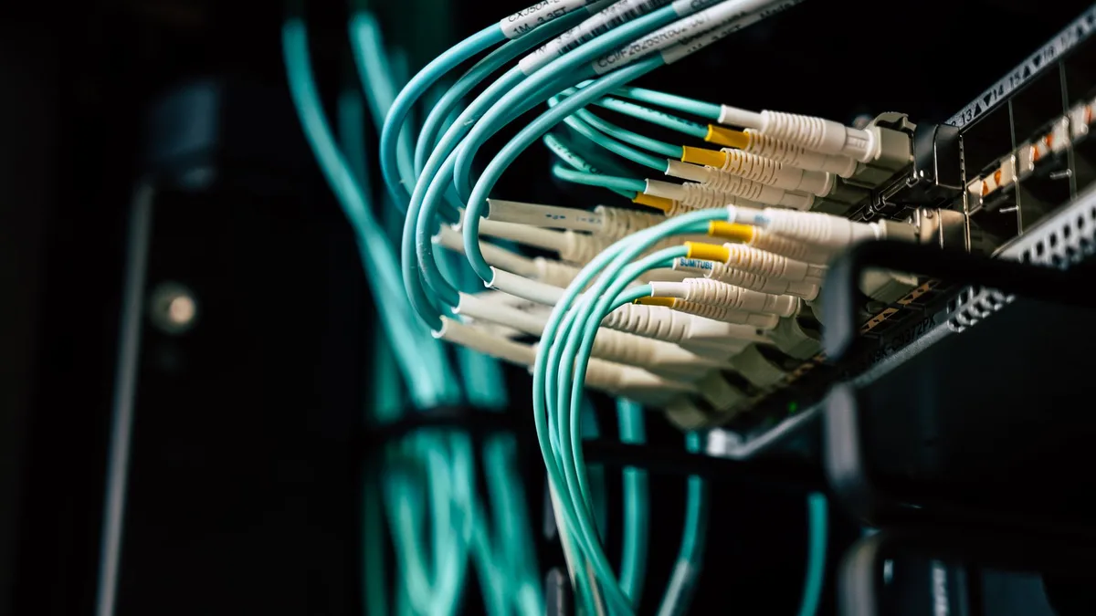 Tangled network cables behind a server rack, integration debt made visible