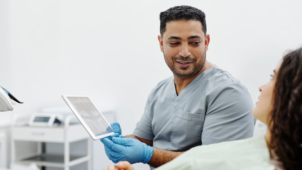 A clinician showing a patient information on a tablet during a consultation
