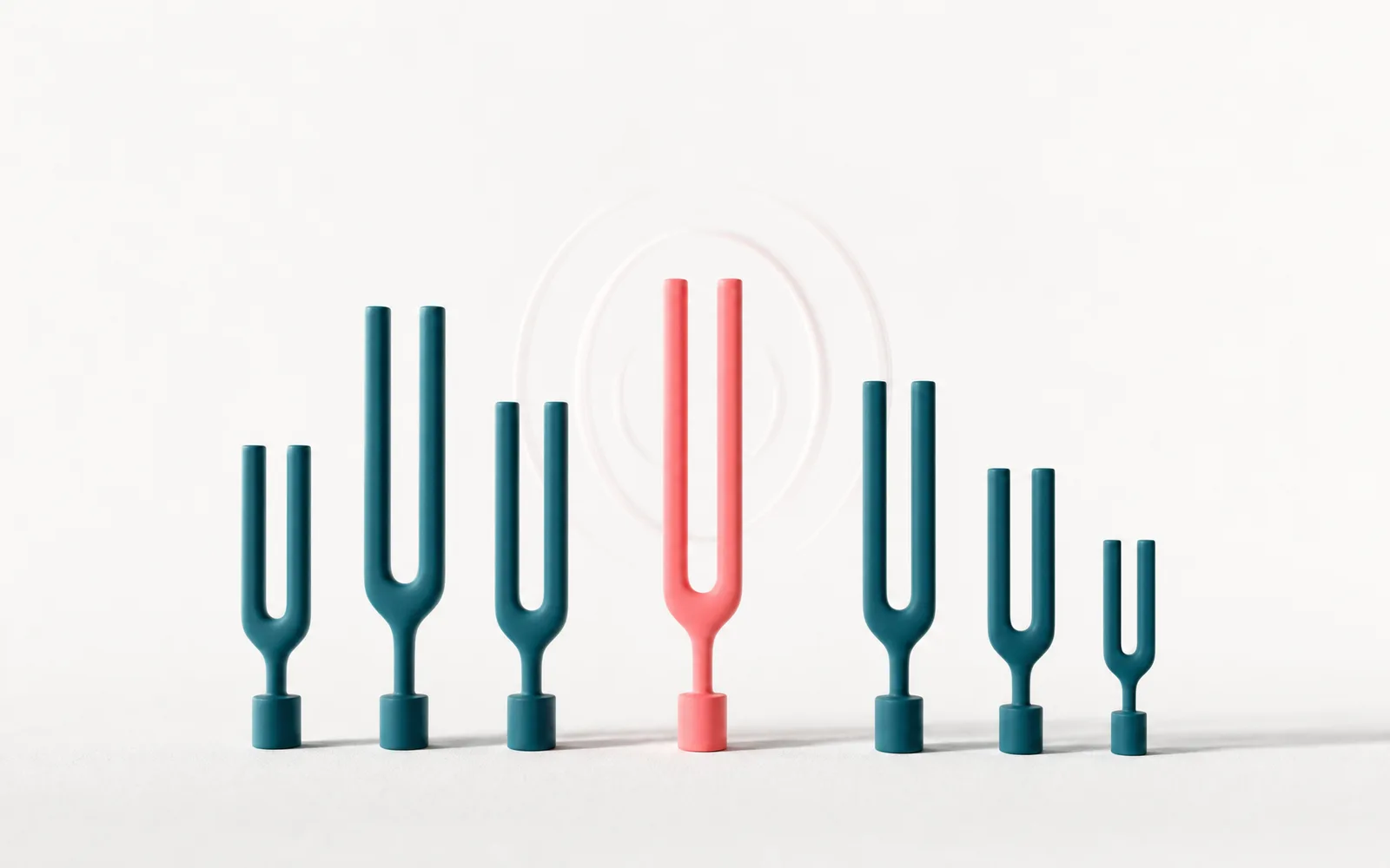 A row of ceramic tuning forks with one resonating in coral, representing choosing the right AI automation partner.