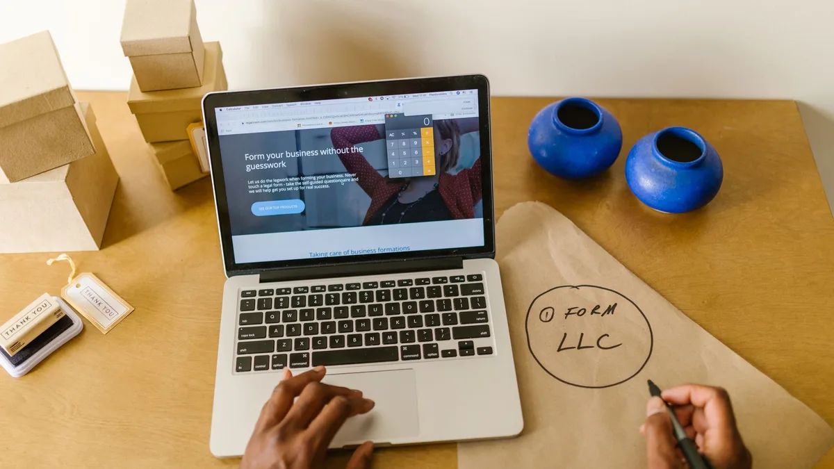 Small business owner reviewing tasks at a desk with a laptop
