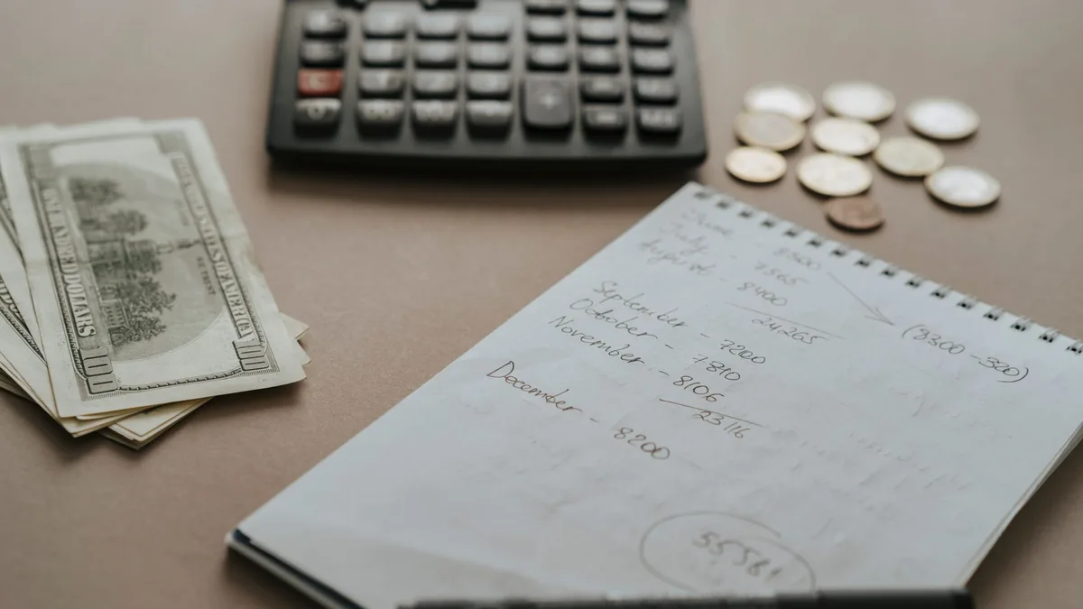 Coins and a notebook representing small business budgeting
